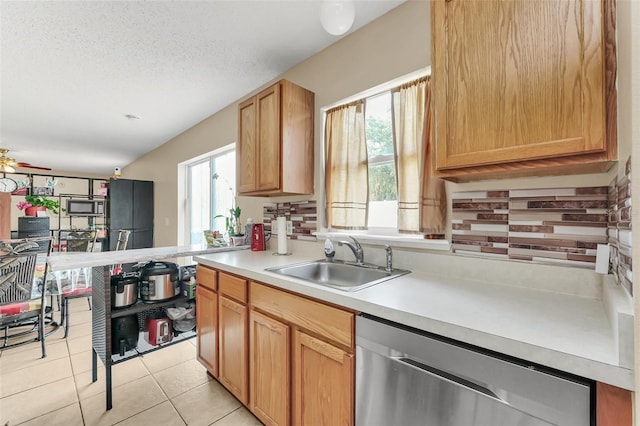 510 Lobelia Dr, Davenport, FL 33837 - kitchen featuring stainless steel dishwasher, a sink, light countertops, light tile patterned floors, and a textured ceiling