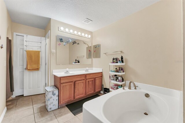 510 Lobelia Dr, Davenport, FL 33837 - bathroom with tile patterned flooring, a garden tub, double vanity, and a textured ceiling