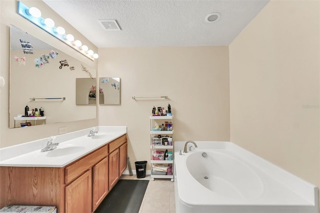 510 Lobelia Dr, Davenport, FL 33837 - bathroom featuring tile patterned floors, a textured ceiling, a bath, and double vanity