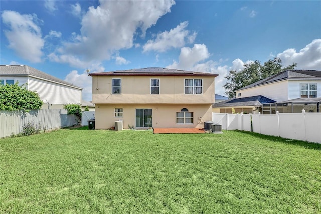 510 Lobelia Dr, Davenport, FL 33837 - rear view of property featuring roof mounted solar panels, stucco siding, and central AC unit