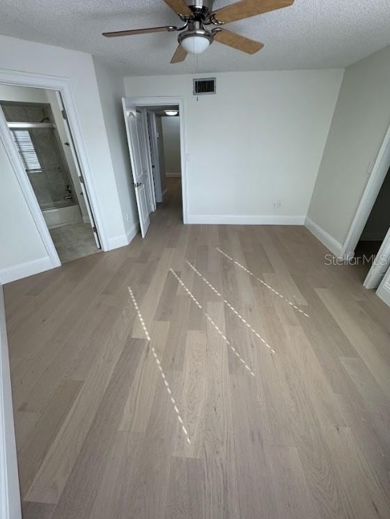 3621 Atrium Dr Unit U-4, Orlando, FL 32822 - unfurnished bedroom featuring a textured ceiling, wood finished floors, baseboards, ensuite bathroom, and ceiling fan