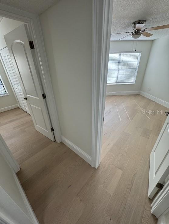 3621 Atrium Dr Unit U-4, Orlando, FL 32822 - hall featuring light wood-style flooring, baseboards, and a textured ceiling