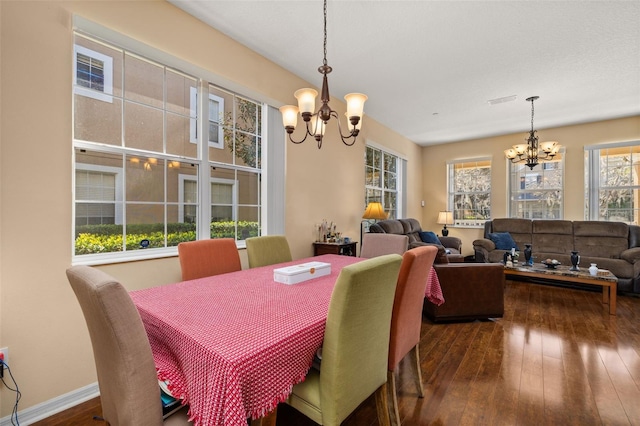 9141 Camden Gardens St, Orlando, FL 32827 - dining area with a chandelier, dark wood finished floors, and baseboards
