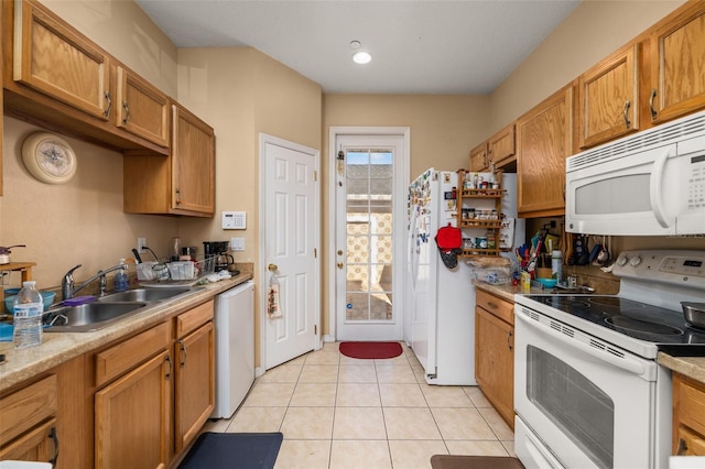 9141 Camden Gardens St, Orlando, FL 32827 - kitchen with white appliances, light tile patterned floors, light countertops, brown cabinets, and a sink