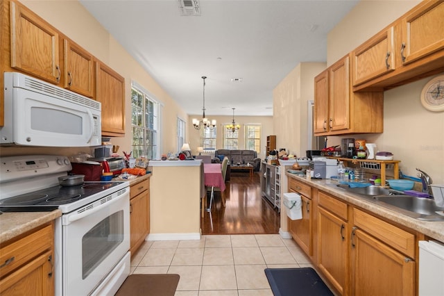 9141 Camden Gardens St, Orlando, FL 32827 - kitchen with white appliances, a sink, a chandelier, light tile patterned floors, and light countertops