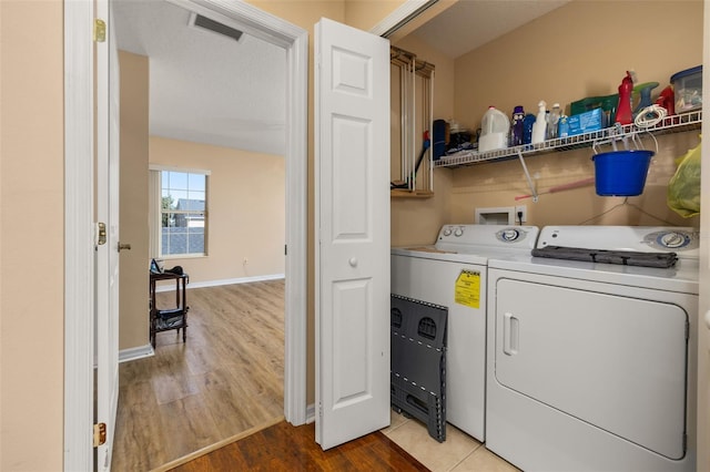 9141 Camden Gardens St, Orlando, FL 32827 - laundry area with washing machine and clothes dryer, cabinet space, and wood finished floors
