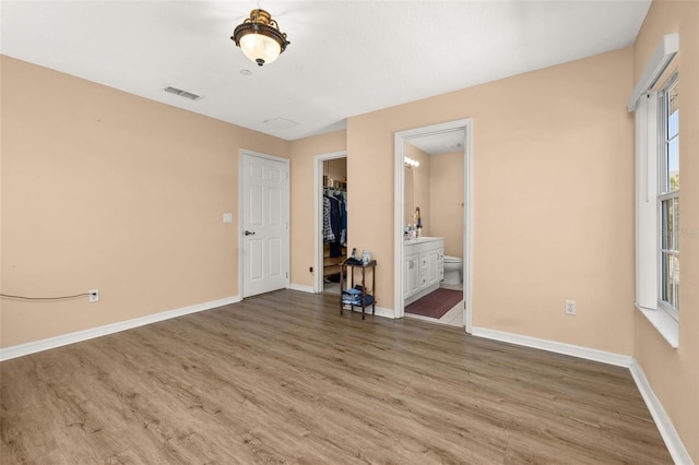 9141 Camden Gardens St, Orlando, FL 32827 - unfurnished bedroom featuring wood finished floors, baseboards, a spacious closet, ensuite bath, and a closet