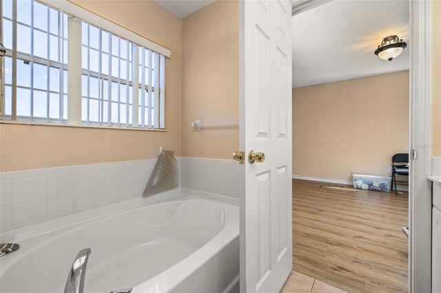 9141 Camden Gardens St, Orlando, FL 32827 - full bathroom with a garden tub and wood finished floors
