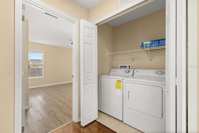 9141 Camden Gardens St, Orlando, FL 32827 - laundry room with washer and dryer and light wood-style flooring