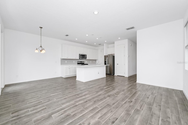 809 Benoi Dr, Davenport, FL 33896 - unfurnished living room with light wood-style floors, recessed lighting, a chandelier, baseboards, and a sink