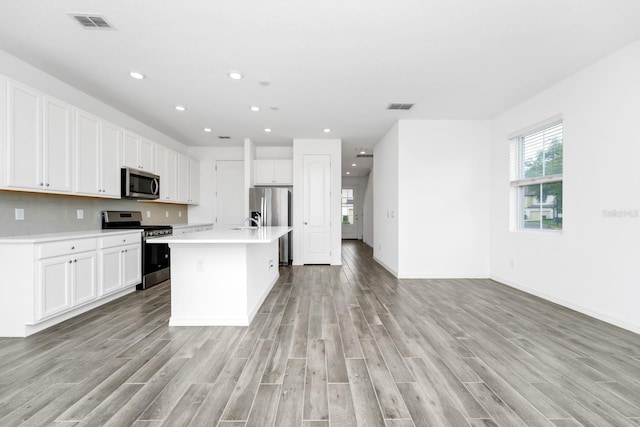 809 Benoi Dr, Davenport, FL 33896 - kitchen featuring stainless steel appliances, light wood-type flooring, light countertops, white cabinets, and recessed lighting