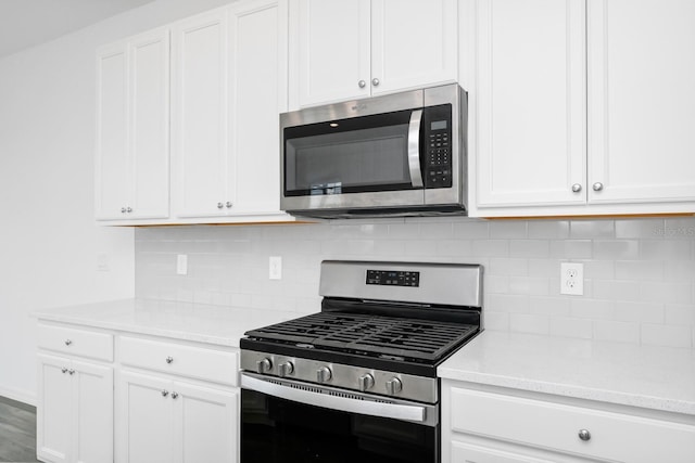 809 Benoi Dr, Davenport, FL 33896 - kitchen featuring appliances with stainless steel finishes, white cabinetry, and tasteful backsplash