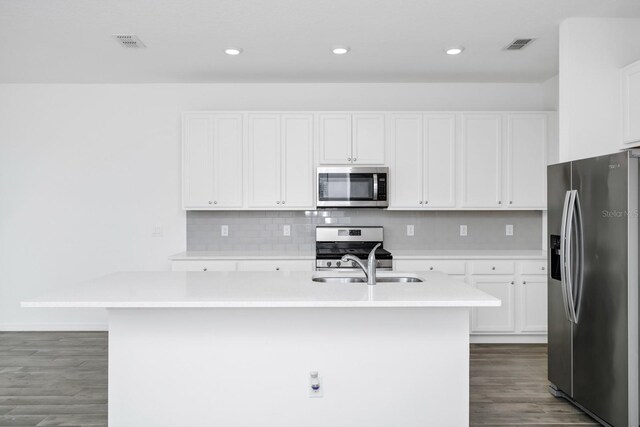 809 Benoi Dr, Davenport, FL 33896 - kitchen featuring appliances with stainless steel finishes, a kitchen island with sink, light countertops, white cabinetry, and recessed lighting
