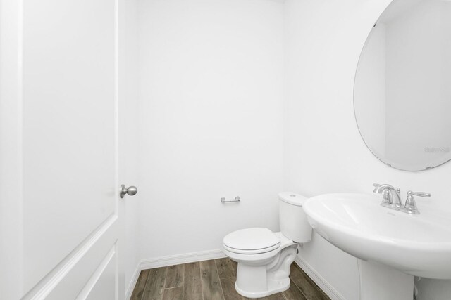 809 Benoi Dr, Davenport, FL 33896 - half bath featuring wood finished floors, toilet, a sink, and baseboards