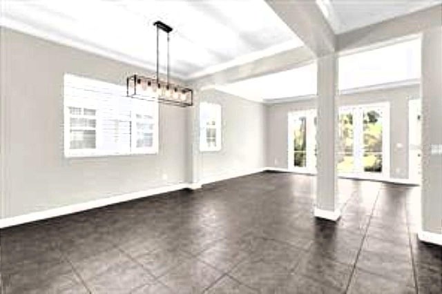 unfurnished dining area with a chandelier and baseboards