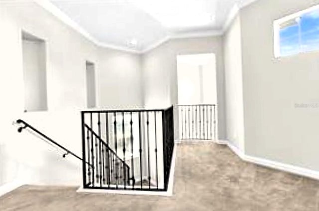 corridor with crown molding, an upstairs landing, baseboards, and carpet