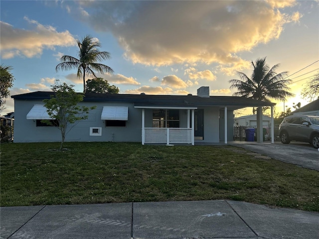 2411 SW 50th Ter, Plantation, FL 33317 - ranch-style house featuring a front yard, covered porch, a carport, stucco siding, and driveway