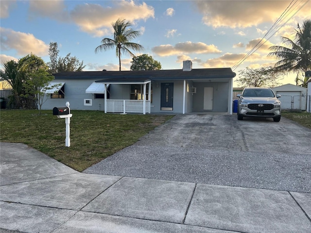2411 SW 50th Ter, Plantation, FL 33317 - single story home with a front yard, a porch, concrete driveway, a chimney, and an attached carport
