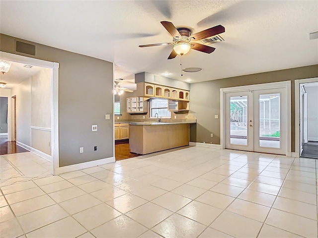 148 Tarrytown Trl, Longwood, FL 32750 - kitchen with a ceiling fan, french doors, a peninsula, a sink, and baseboards