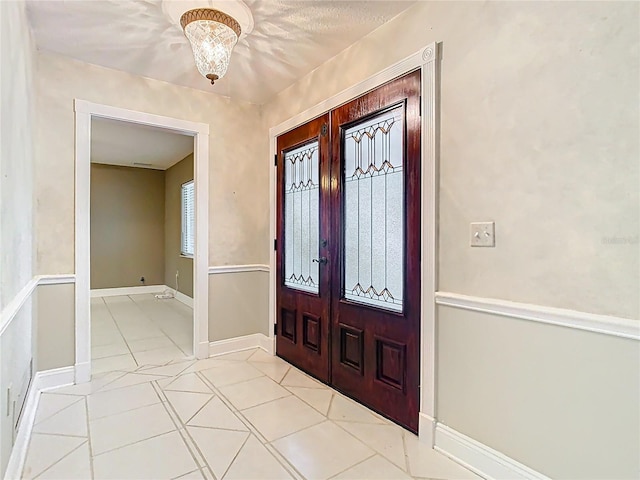 148 Tarrytown Trl, Longwood, FL 32750 - foyer with french doors, light tile patterned floors, a chandelier, and baseboards
