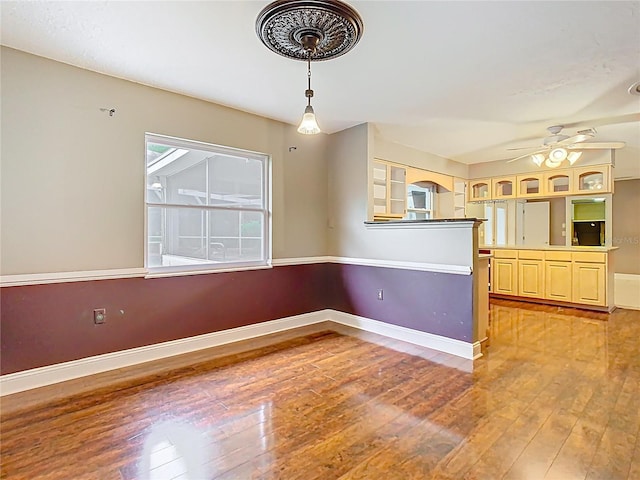 148 Tarrytown Trl, Longwood, FL 32750 - kitchen featuring light wood finished floors, a ceiling fan, baseboards, pendant lighting, and arched walkways