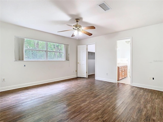 148 Tarrytown Trl, Longwood, FL 32750 - unfurnished bedroom with dark wood-type flooring, baseboards, a walk in closet, a closet, and ceiling fan