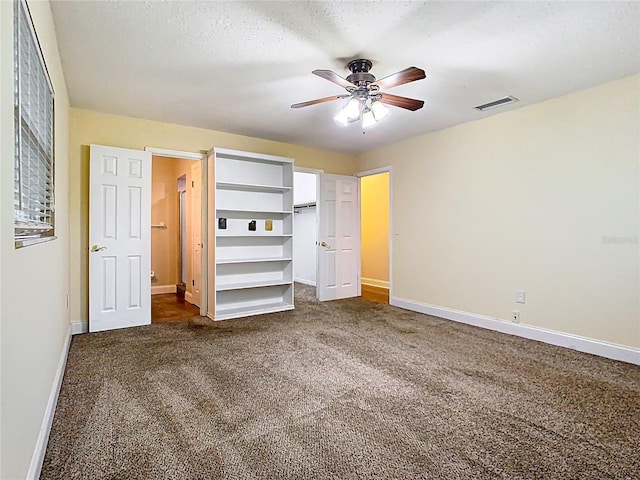 148 Tarrytown Trl, Longwood, FL 32750 - unfurnished bedroom with dark colored carpet, baseboards, a walk in closet, a ceiling fan, and a closet