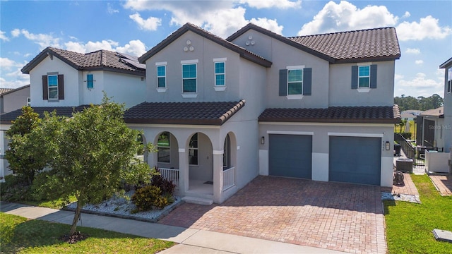 9845 Emerald Berry Dr, Winter Garden, FL 34787 - mediterranean / spanish home with covered porch, a garage, a tiled roof, and stucco siding
