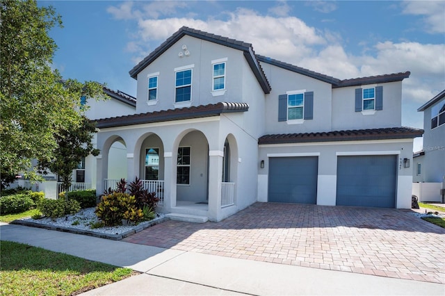 9845 Emerald Berry Dr, Winter Garden, FL 34787 - mediterranean / spanish-style house with a porch, an attached garage, decorative driveway, and stucco siding