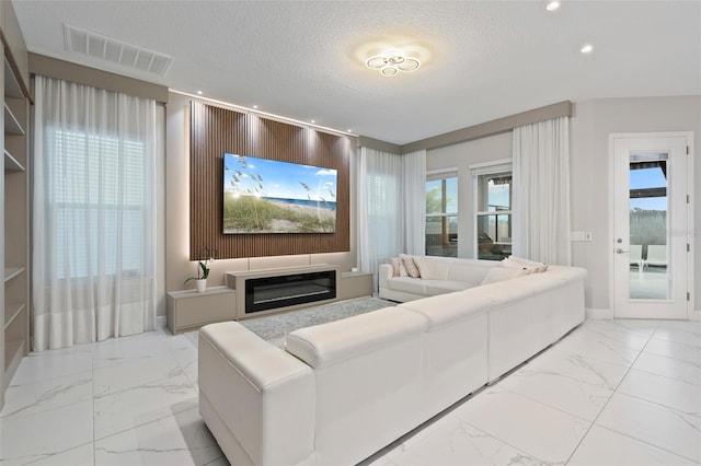 9845 Emerald Berry Dr, Winter Garden, FL 34787 - living room featuring light marble finish floors, a textured ceiling, and recessed lighting