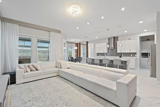 9845 Emerald Berry Dr, Winter Garden, FL 34787 - living room featuring recessed lighting, a textured ceiling, and a chandelier