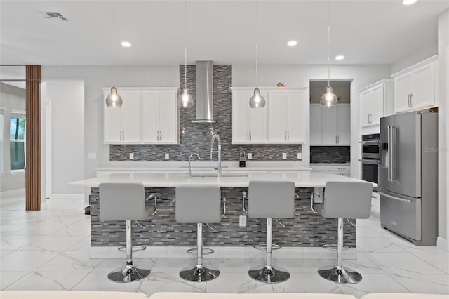 9845 Emerald Berry Dr, Winter Garden, FL 34787 - kitchen featuring stainless steel appliances, a kitchen bar, tasteful backsplash, light marble finish flooring, and recessed lighting