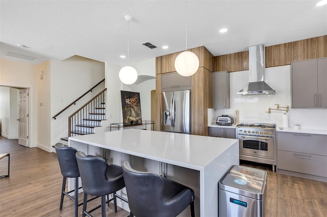 8430 Woburn Ct, Windermere, FL 34786 - kitchen with appliances with stainless steel finishes, wall chimney range hood, a kitchen island, light countertops, and recessed lighting