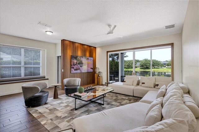 8430 Woburn Ct, Windermere, FL 34786 - living area featuring healthy amount of natural light, wood finished floors, a ceiling fan, a textured ceiling, and baseboards