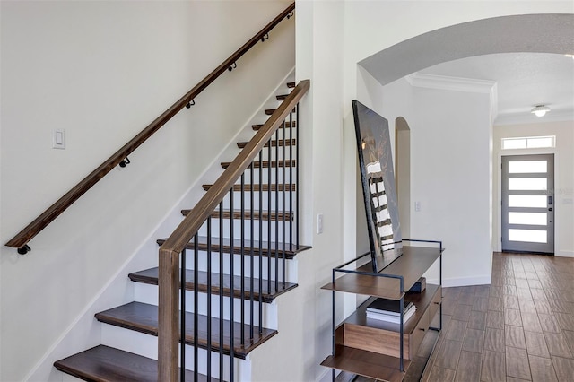 8430 Woburn Ct, Windermere, FL 34786 - stairs featuring arched walkways, ornamental molding, wood finish floors, and baseboards