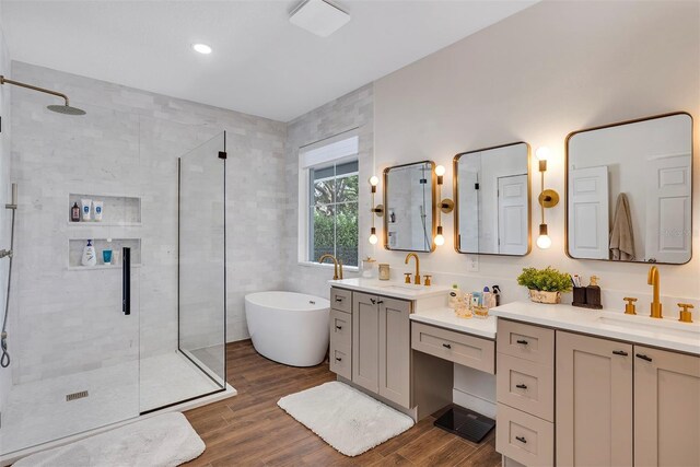 8430 Woburn Ct, Windermere, FL 34786 - full bath featuring a stall shower, two vanities, a soaking tub, and wood finished floors