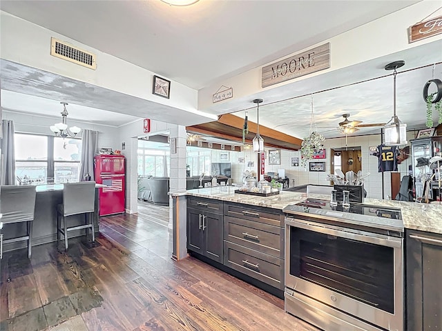 3788 N Econlockhatchee Trl, Orlando, FL 32817 - kitchen featuring stainless steel range with electric cooktop, ceiling fan, dark wood-style floors, light stone countertops, and a chandelier