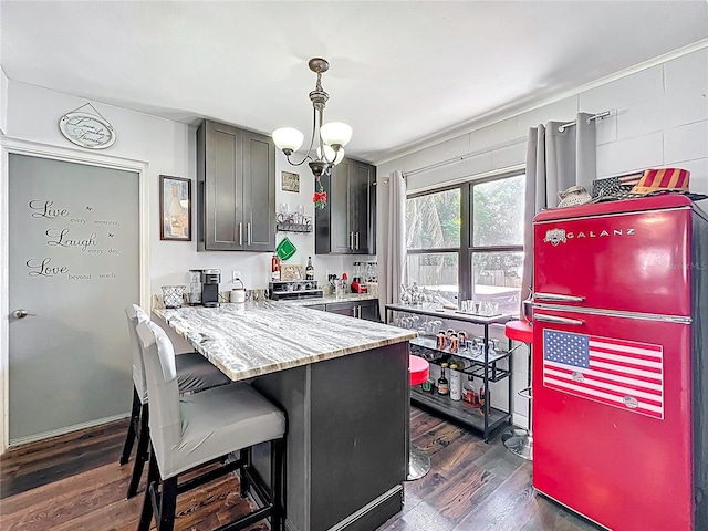3788 N Econlockhatchee Trl, Orlando, FL 32817 - kitchen featuring dark wood-type flooring, a kitchen breakfast bar, a chandelier, hanging light fixtures, and a peninsula