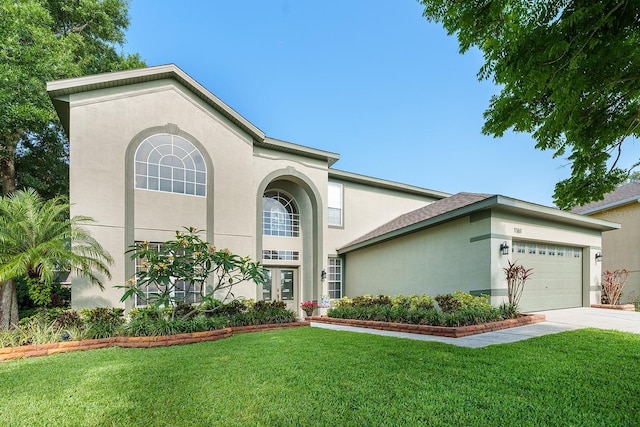 view of front of home with stucco siding, a garage, a front yard, and concrete driveway