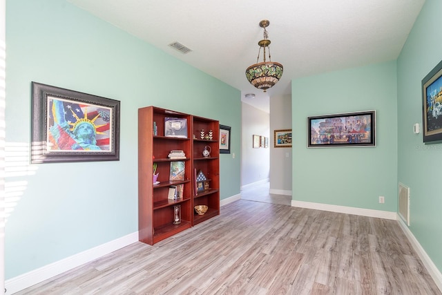 empty room with light wood finished floors and baseboards
