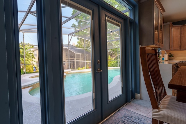 doorway to outside with a sink, healthy amount of natural light, french doors, and light tile patterned flooring