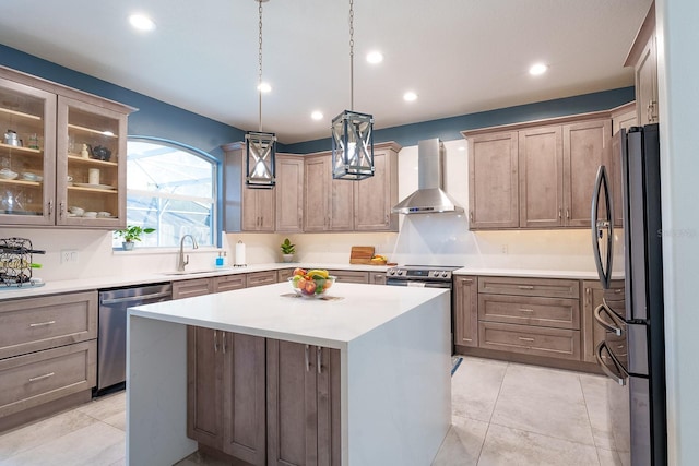 kitchen featuring wall chimney range hood, appliances with stainless steel finishes, a sink, a center island, and recessed lighting