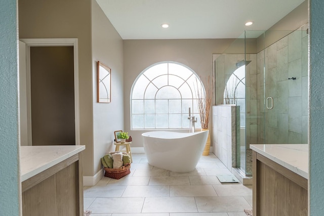 bathroom featuring a stall shower, a soaking tub, tile patterned floors, recessed lighting, and baseboards