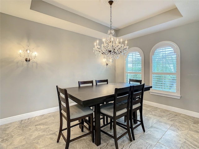 8491 Pippen Dr, Orlando, FL 32836 - dining room featuring a chandelier, a raised ceiling, and baseboards