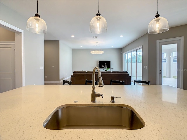 8491 Pippen Dr, Orlando, FL 32836 - kitchen featuring a sink, light stone counters, pendant lighting, and recessed lighting
