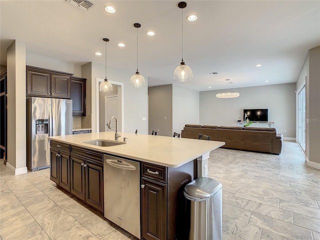 8491 Pippen Dr, Orlando, FL 32836 - kitchen with a sink, stainless steel appliances, light countertops, dark brown cabinets, and a kitchen island with sink