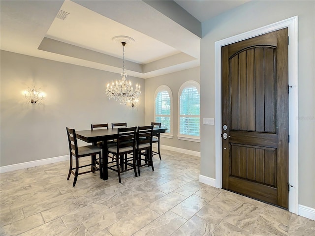 8491 Pippen Dr, Orlando, FL 32836 - dining area featuring a chandelier, a raised ceiling, and baseboards
