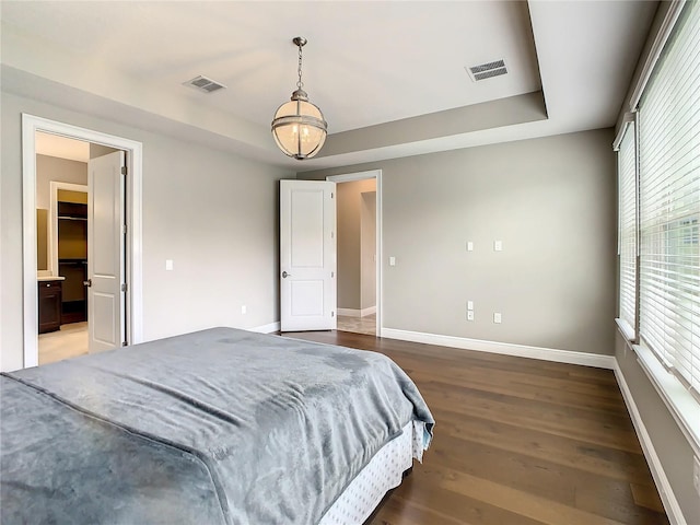 8491 Pippen Dr, Orlando, FL 32836 - bedroom with a tray ceiling, baseboards, and wood finished floors