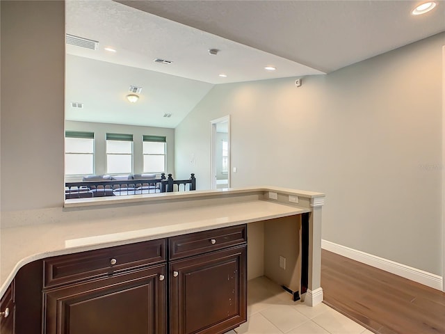 8491 Pippen Dr, Orlando, FL 32836 - kitchen featuring dark brown cabinets, light countertops, lofted ceiling, baseboards, and recessed lighting