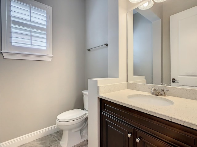 8491 Pippen Dr, Orlando, FL 32836 - bathroom with toilet, baseboards, vanity, and marble look tiles